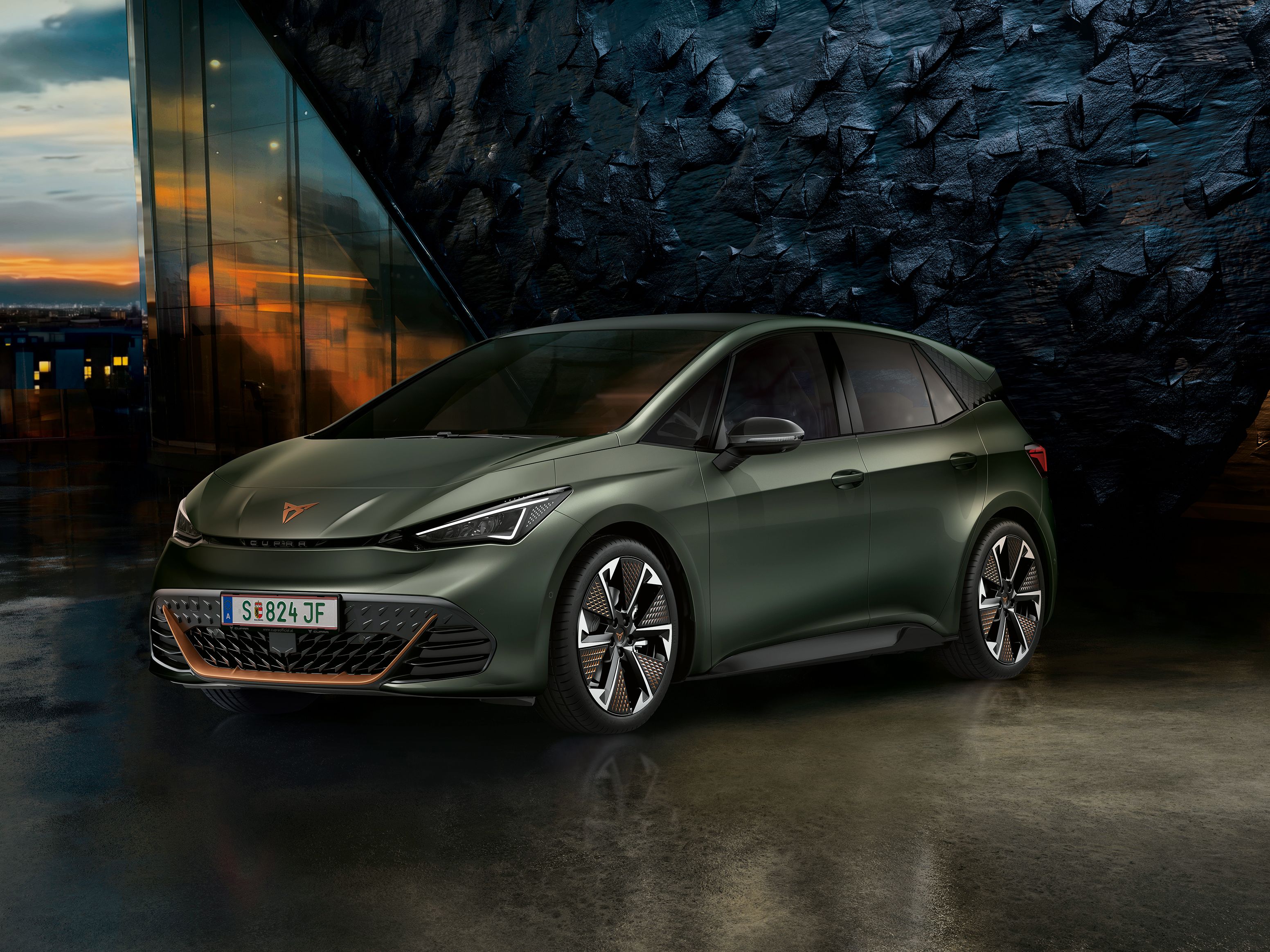 CUPRA Born vor einer Steinwand bei Sonnenuntergang