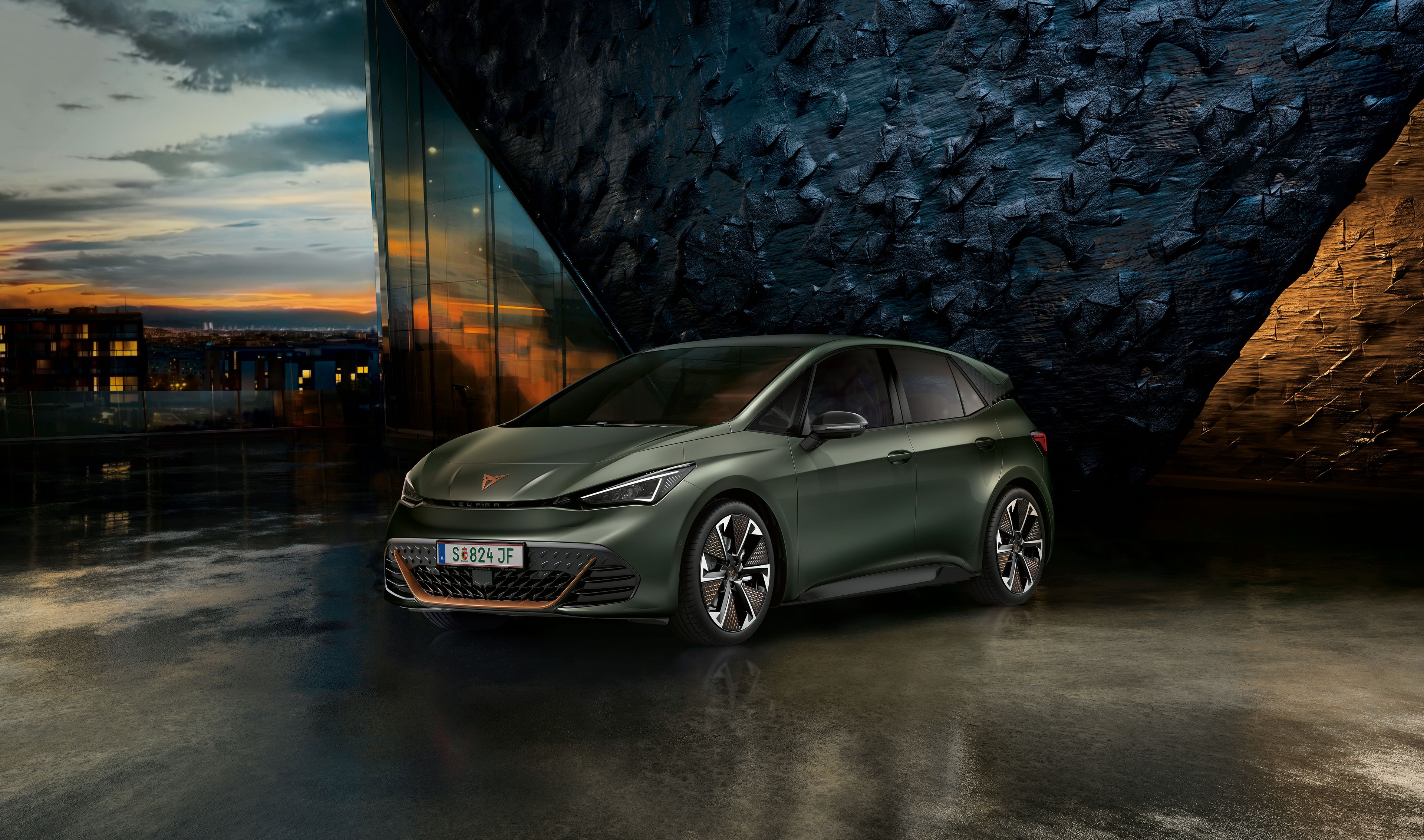 CUPRA Born vor einer Steinwand bei Sonnenuntergang