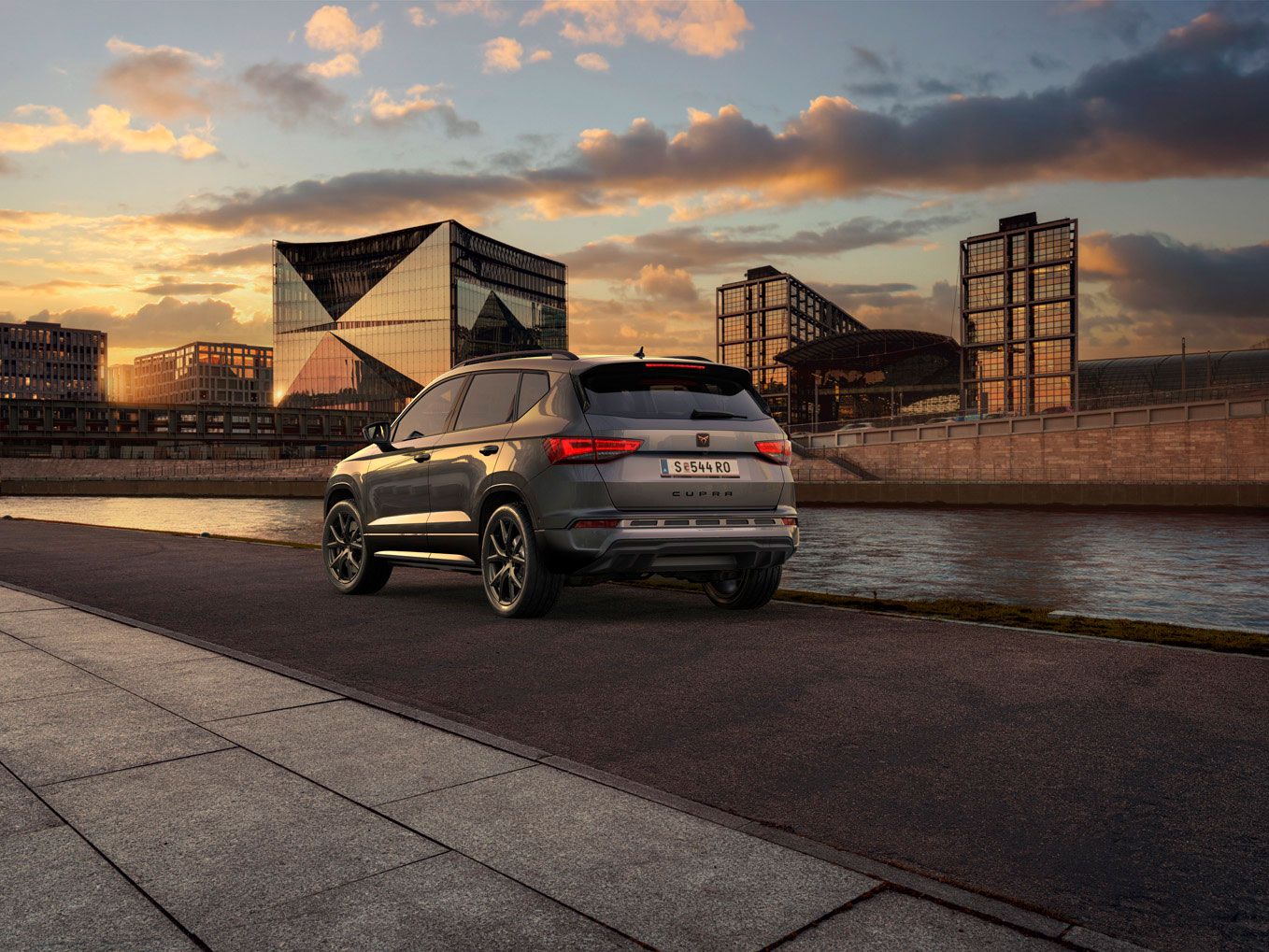 Heckansicht des CUPRA Ateca SUVs bei Sonnenuntergang, mit Fokus auf den neuen, niedrigeren Frontgrill mit Luftkappen und den neuen Heckdiffusor, die beide das äußere Design verstärken und die Aerodynamik optimieren.