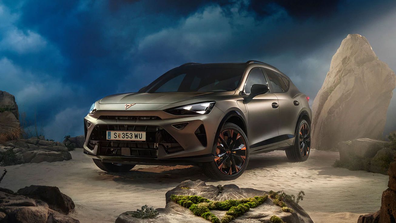 Ein CUPRA Formentor VZ in Bronze steht dramatisch beleuchtet in einer felsigen, nebeligen Landschaft. Eine Lichtstrahl beleuchtet das Fahrzeug und betont seine Konturen. Im Hintergrund sind Felsen und Pflanzen zu sehen.