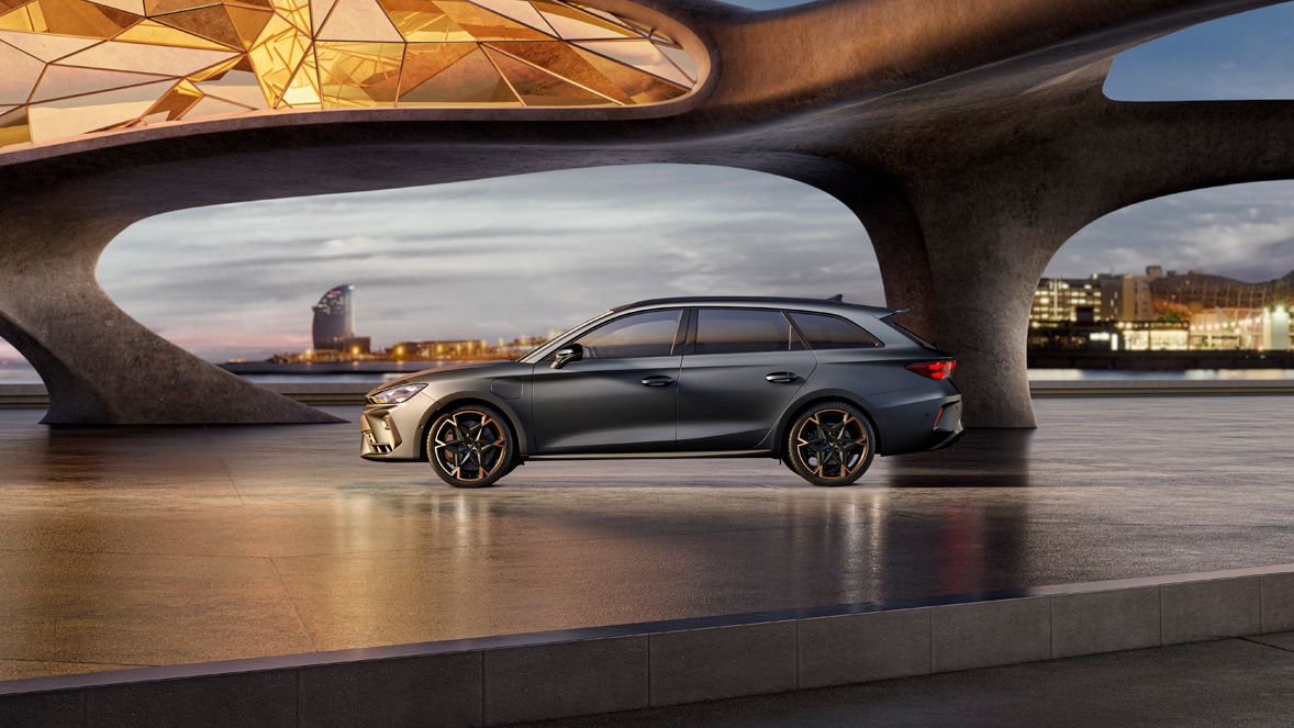 Seitenansicht eines grauen CUPRA Leon SP Kombi, der in einem modernen Parkhaus parkt.