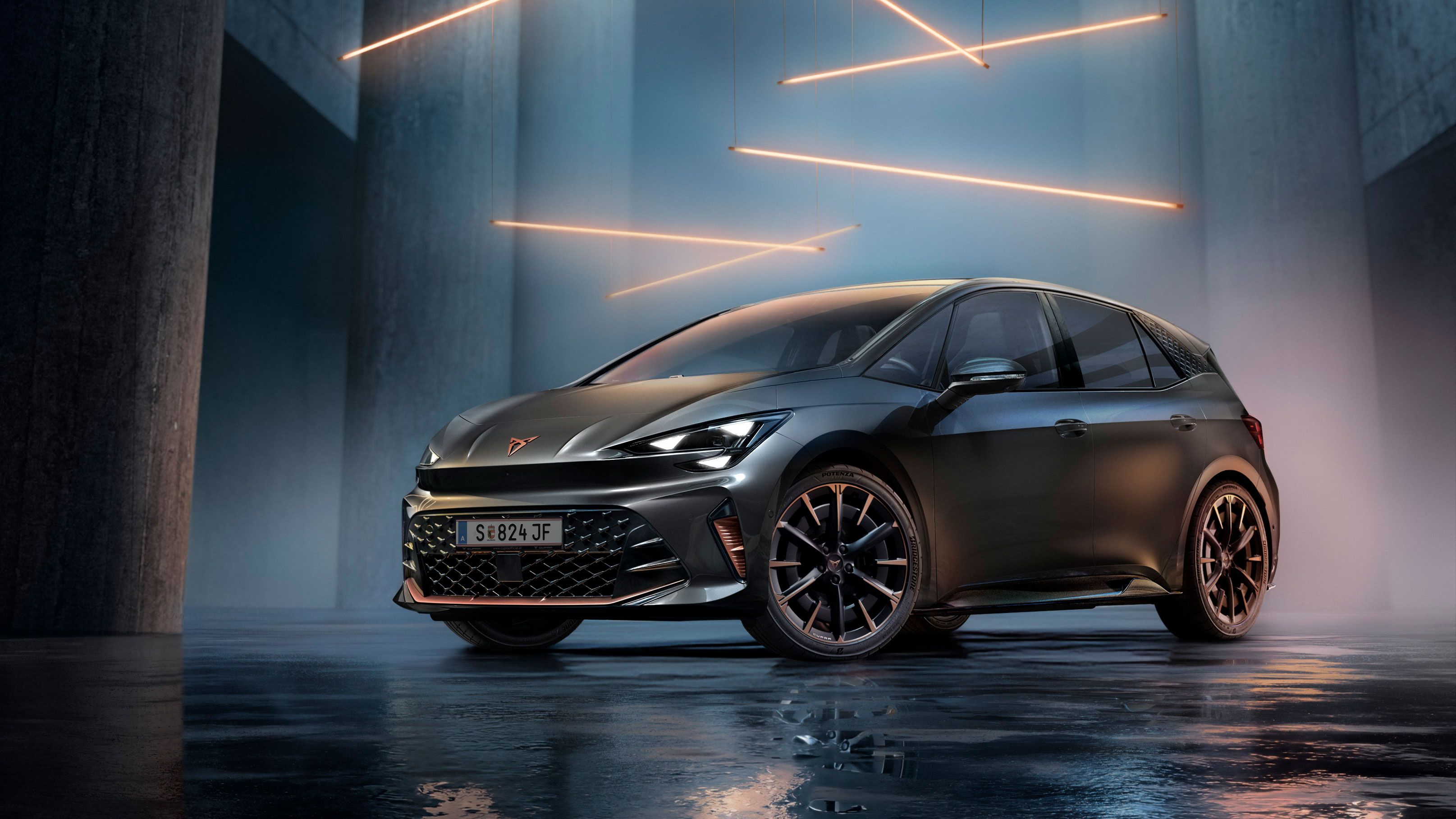 Ein grauer CUPRA Born steht in einer modernen, dunklen Umgebung mit vertikalen Säulen und leuchtenden LED-Streifen. Der Boden ist glänzend und reflektiert das Fahrzeug sowie die Beleuchtung. Das Auto wirkt kraftvoll und elegant.