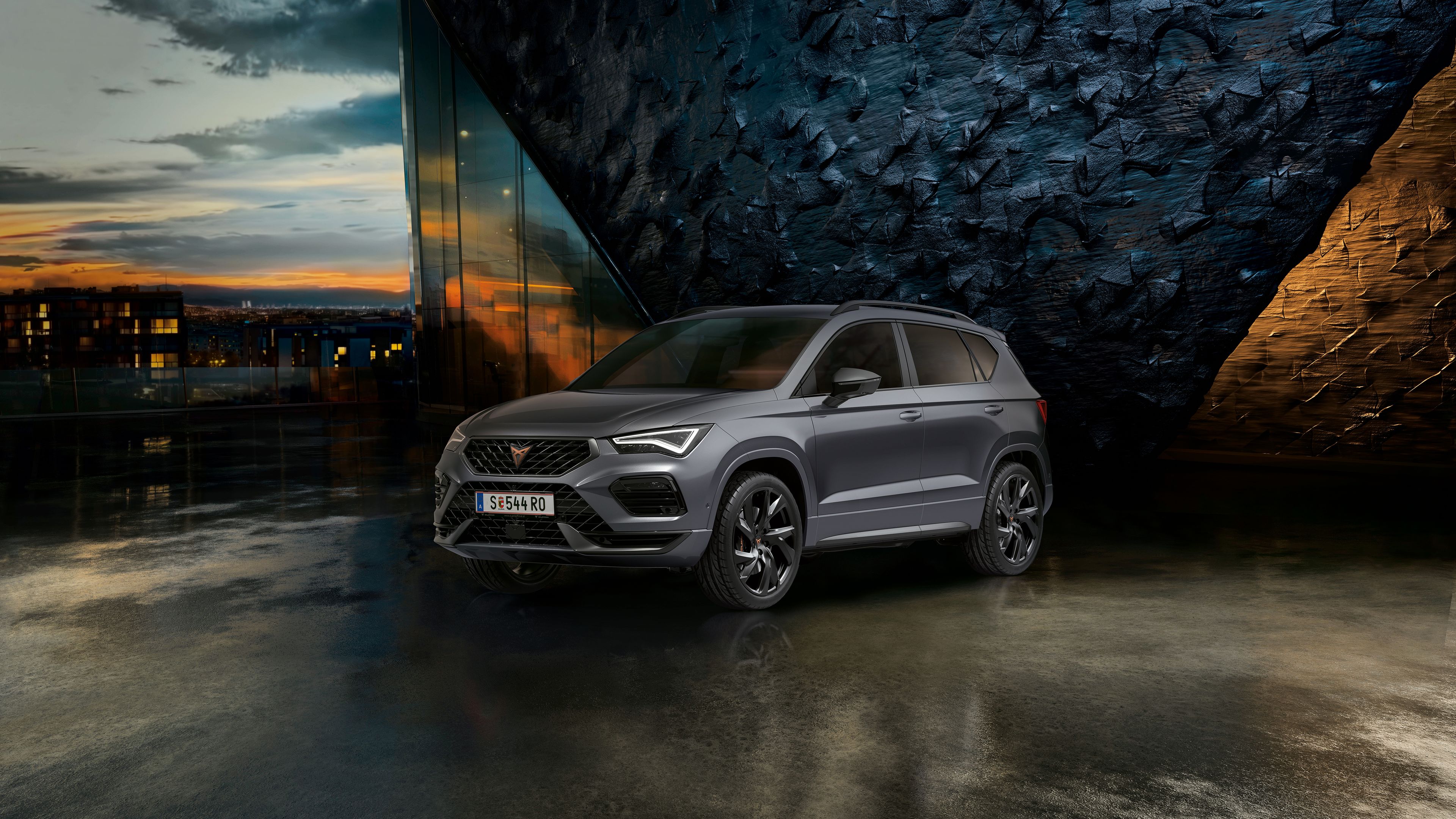 CUPRA Ateca vor einer Steinwand bei Sonnenuntergang