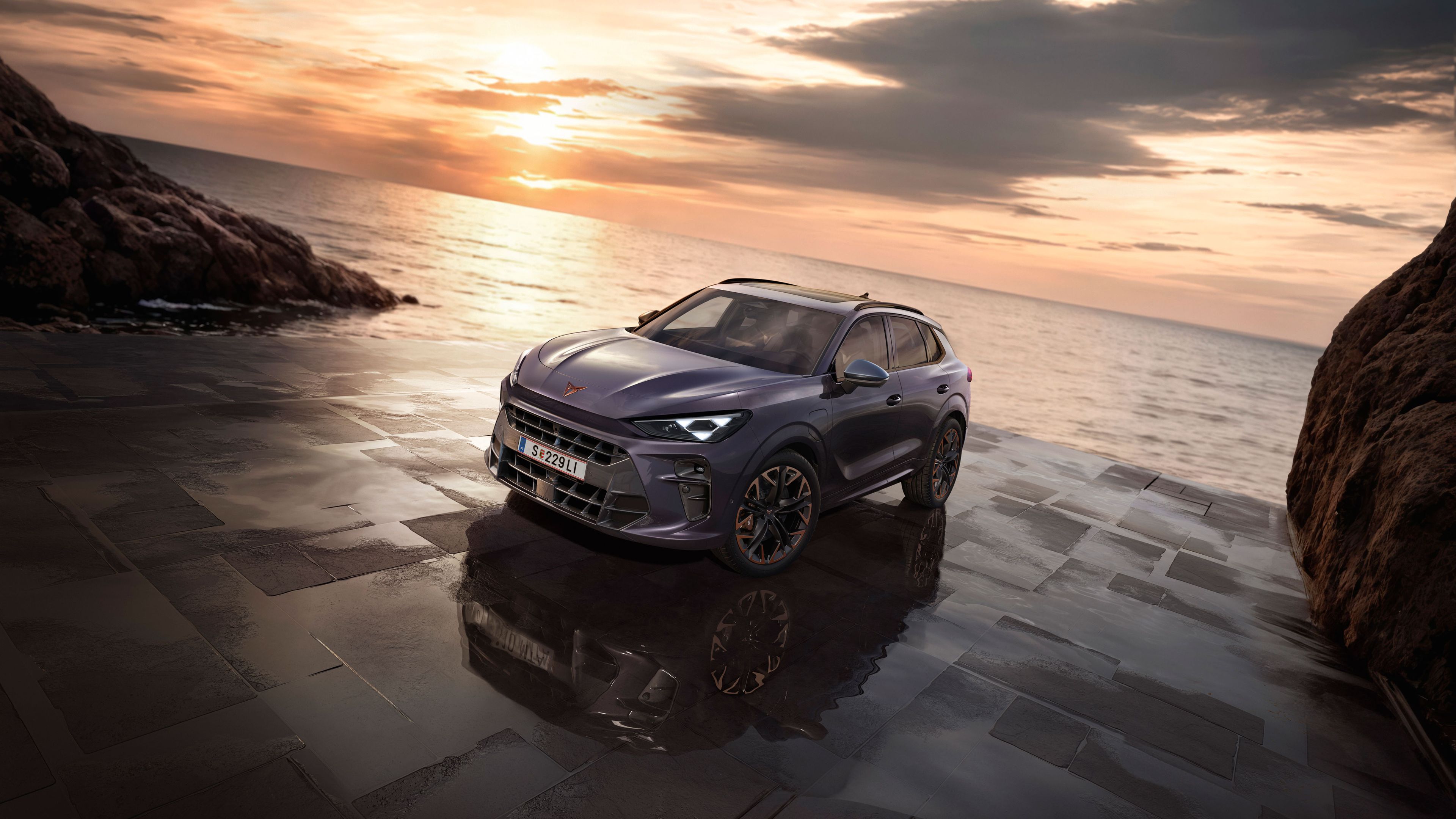 Ein CUPRA Terramar parkt zwischen Felsen an der Meeresküste.