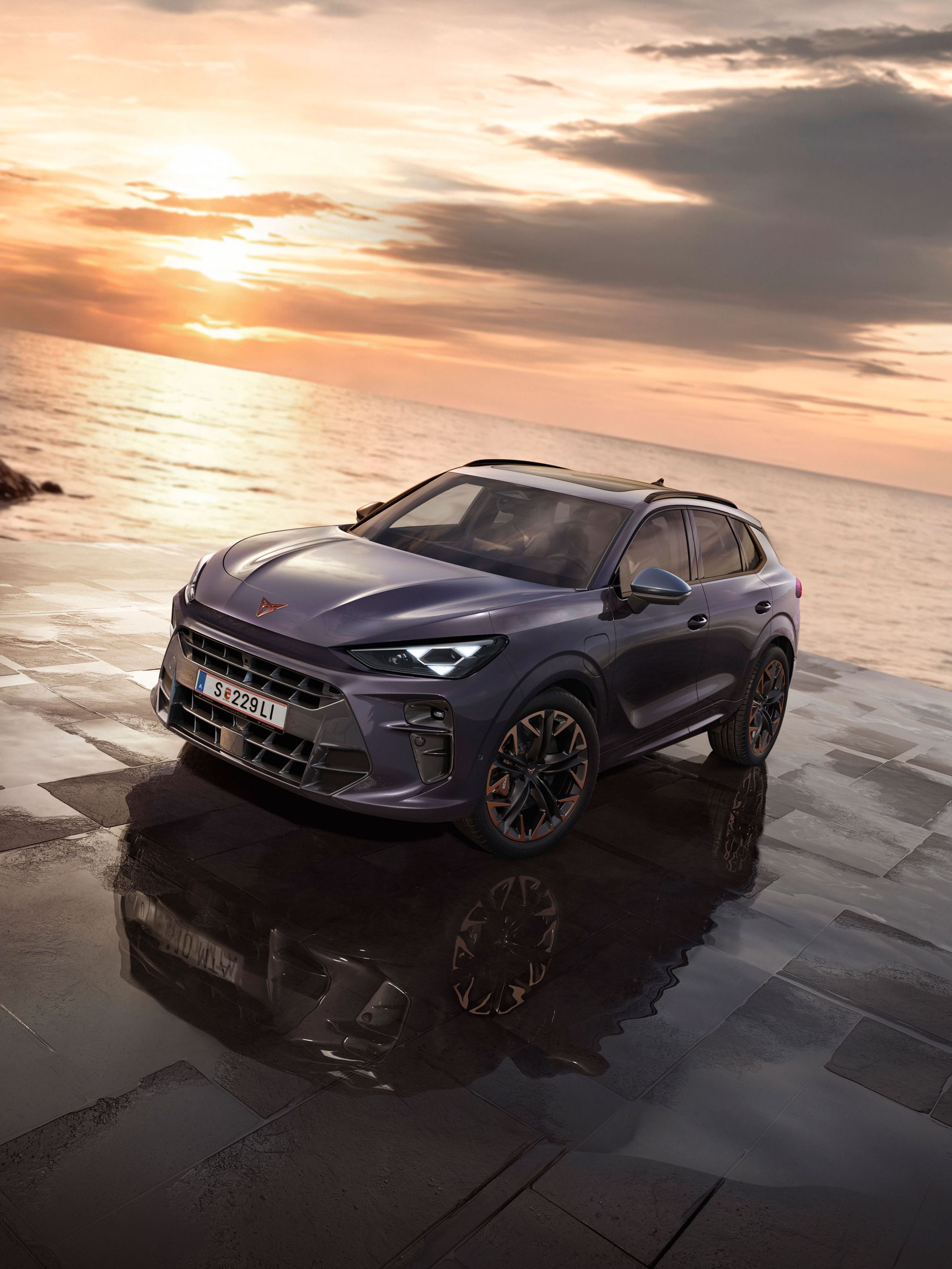 Ein CUPRA Terramar parkt zwischen Felsen an der Meeresküste.