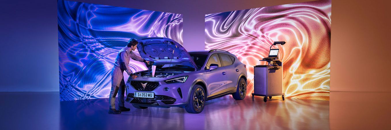 Ein CUPRA Techniker mit Diagnosegeräten öffnet die Motorhaube eines CUPRA Formentor.