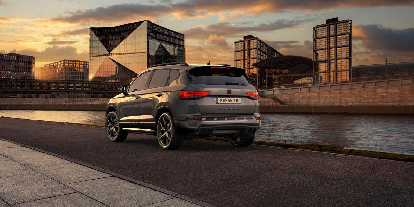 Heckansicht des CUPRA Ateca SUVs bei Sonnenuntergang, mit Fokus auf den neuen, niedrigeren Frontgrill mit Luftkappen und den neuen Heckdiffusor, die beide das äußere Design verstärken und die Aerodynamik optimieren.
