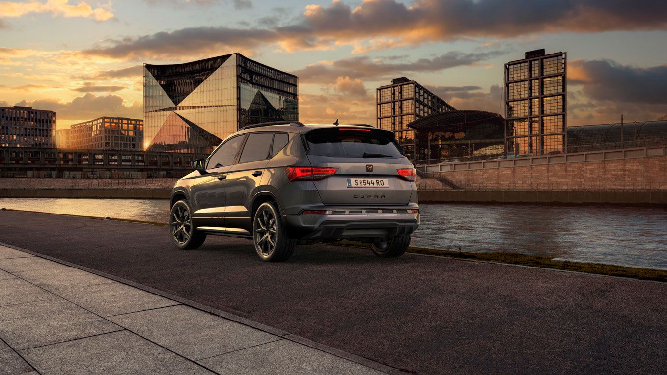 Heckansicht des CUPRA Ateca SUVs bei Sonnenuntergang, mit Fokus auf den neuen, niedrigeren Frontgrill mit Luftkappen und den neuen Heckdiffusor, die beide das äußere Design verstärken und die Aerodynamik optimieren.