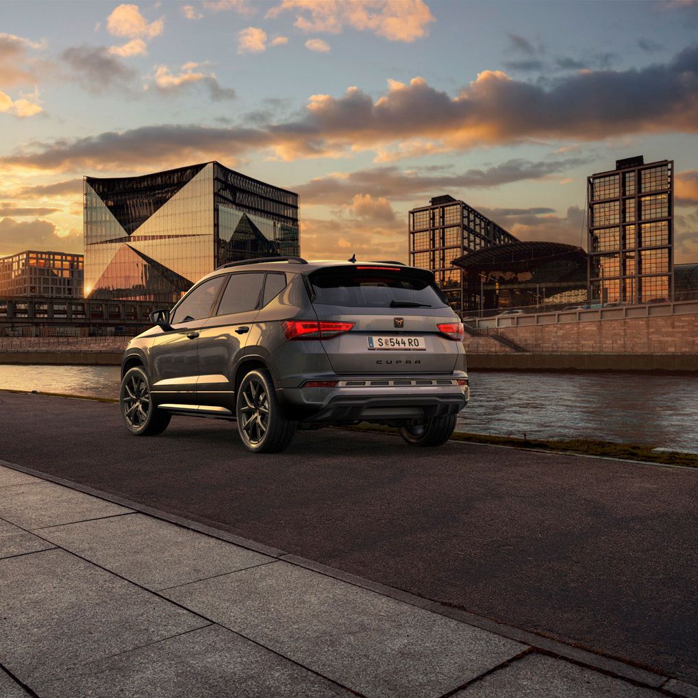 Heckansicht des CUPRA Ateca SUVs bei Sonnenuntergang, mit Fokus auf den neuen, niedrigeren Frontgrill mit Luftkappen und den neuen Heckdiffusor, die beide das äußere Design verstärken und die Aerodynamik optimieren.