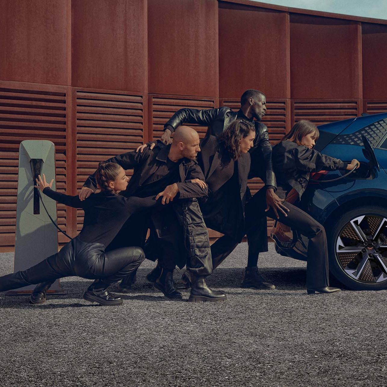 Eine Gruppe von Personen beim Aufladen eines blauen CUPRA Born an der Ladesäule.