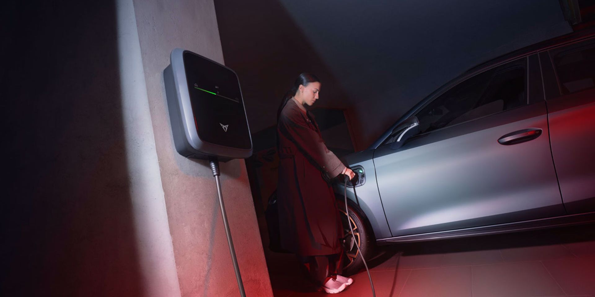 Eine Frau lädt einen grauen CUPRA Leon an einem CUPRA Charger.