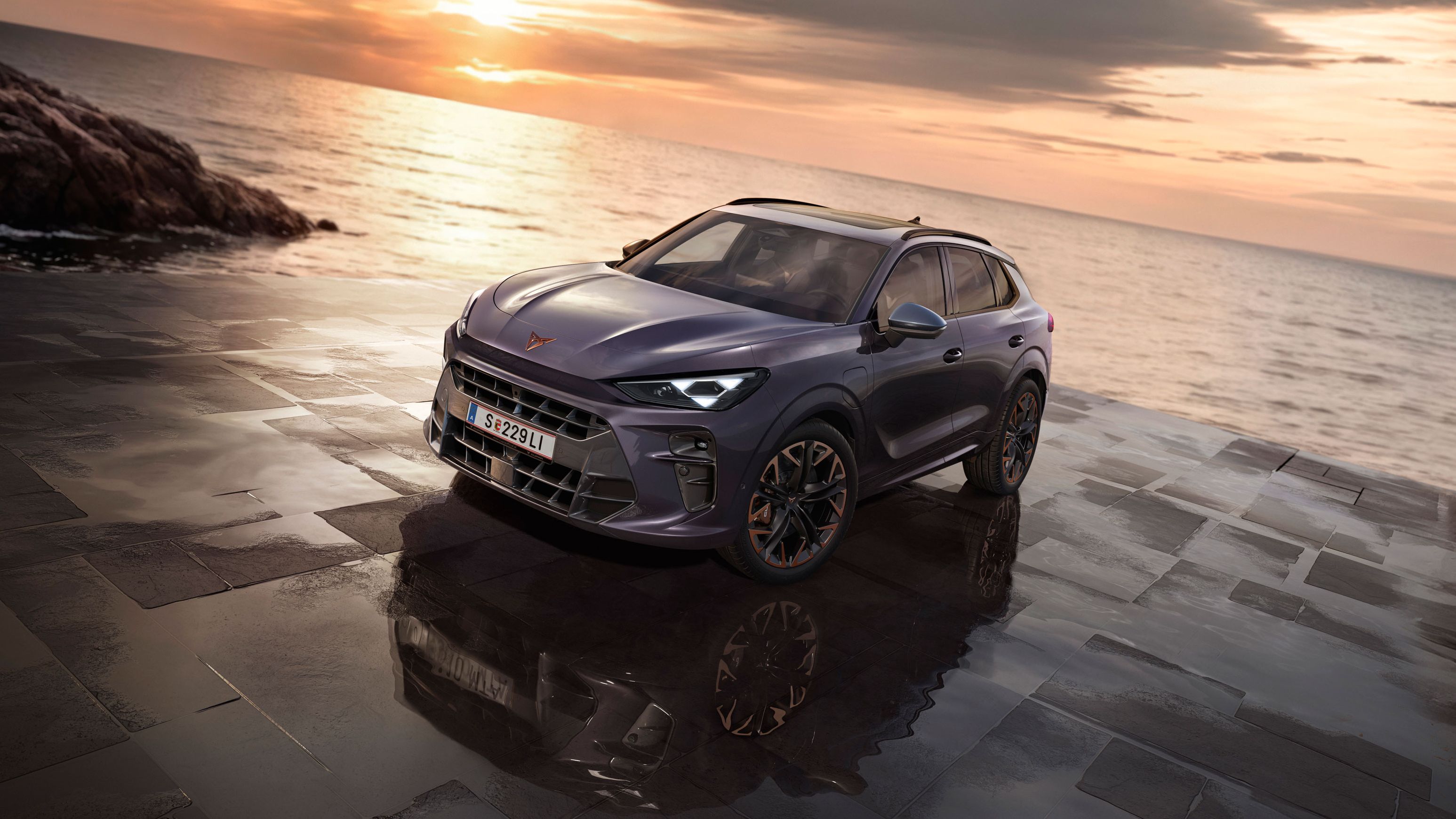 Ein CUPRA Terramar parkt zwischen Felsen an der Meeresküste.