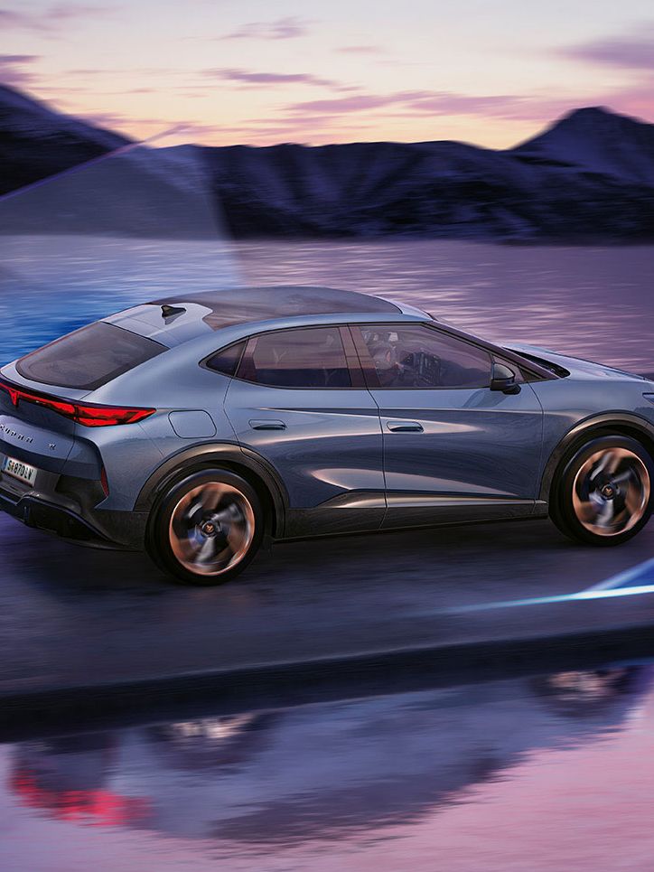 CUPRA Tavascan Seitenansicht vor See mit Bergen im Hintergrund