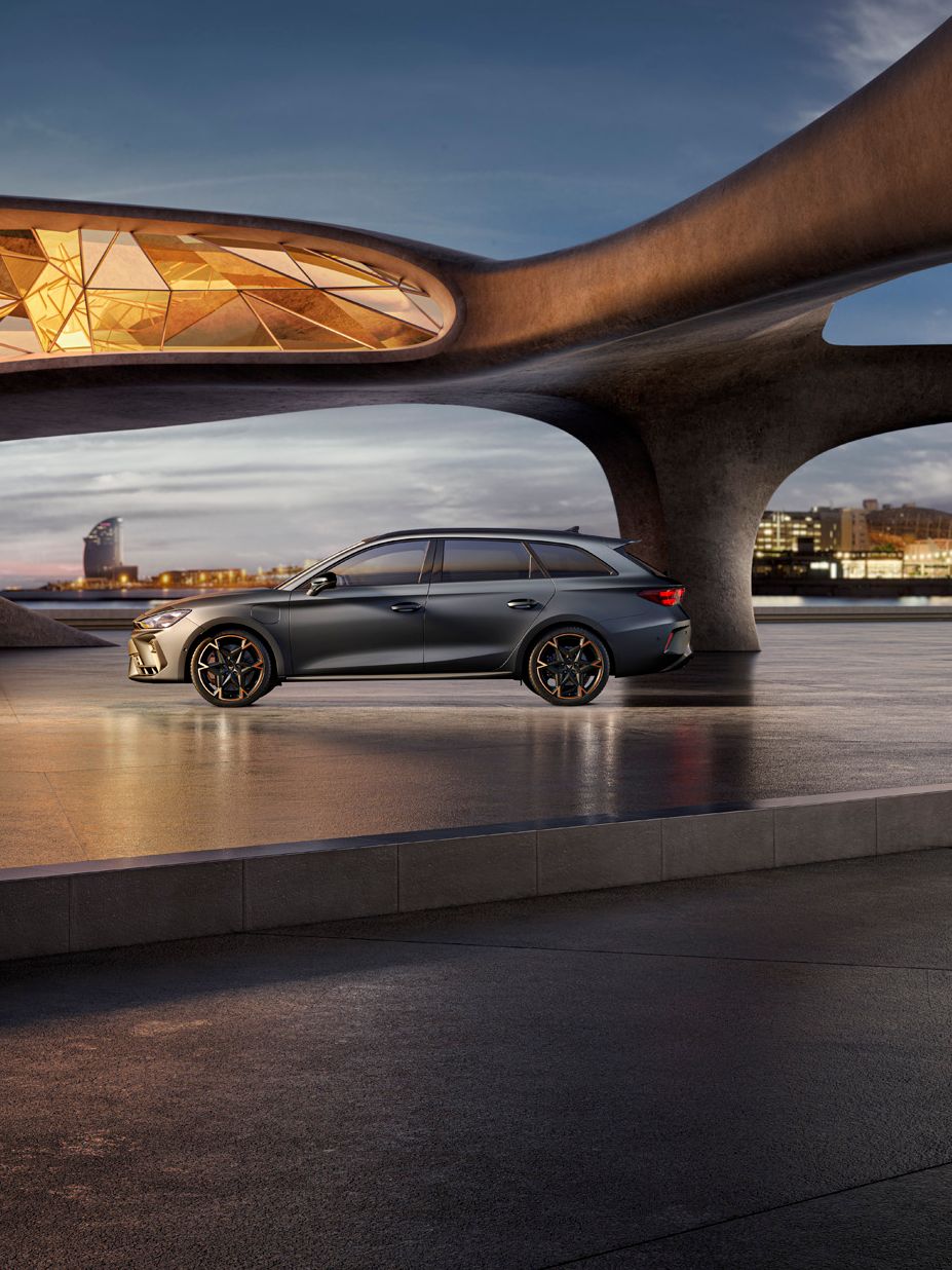 Seitenansicht eines grauen CUPRA Leon SP Kombi, der in einem modernen Parkhaus parkt.