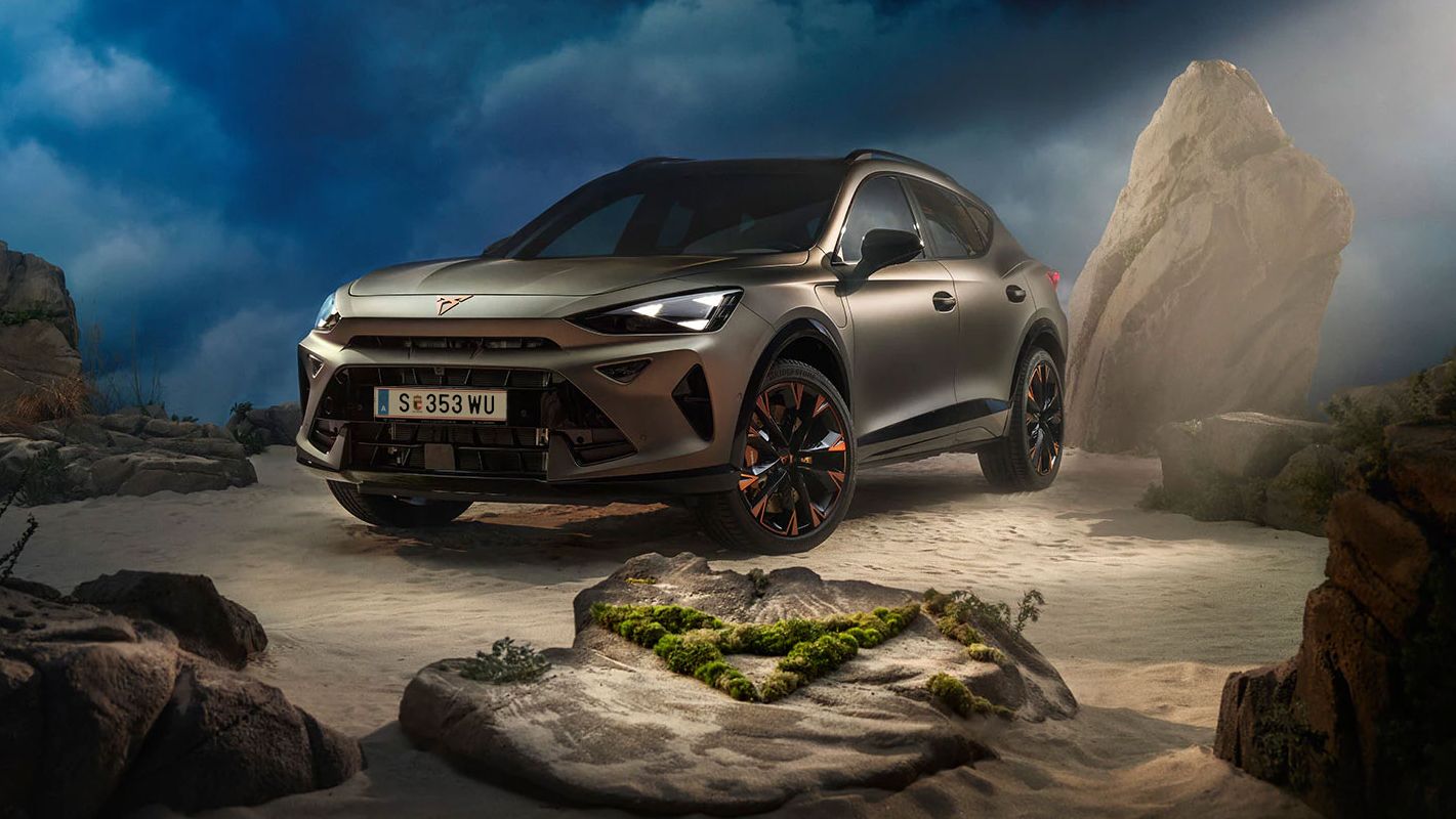 Ein CUPRA Formentor VZ in Bronze steht dramatisch beleuchtet in einer felsigen, nebeligen Landschaft. Eine Lichtstrahl beleuchtet das Fahrzeug und betont seine Konturen. Im Hintergrund sind Felsen und Pflanzen zu sehen.