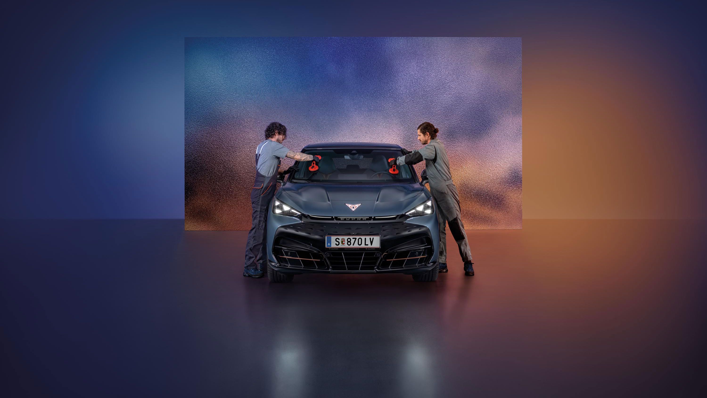 Zwei CUPRA Mechaniker tauschen die Windschutzscheibe bei einem CUPRA Born.