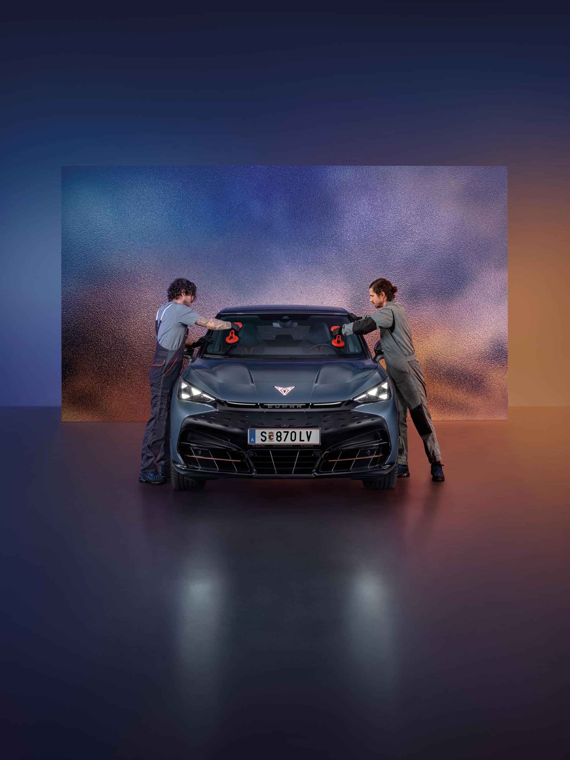 Zwei CUPRA Mechaniker tauschen die Windschutzscheibe bei einem CUPRA Born.