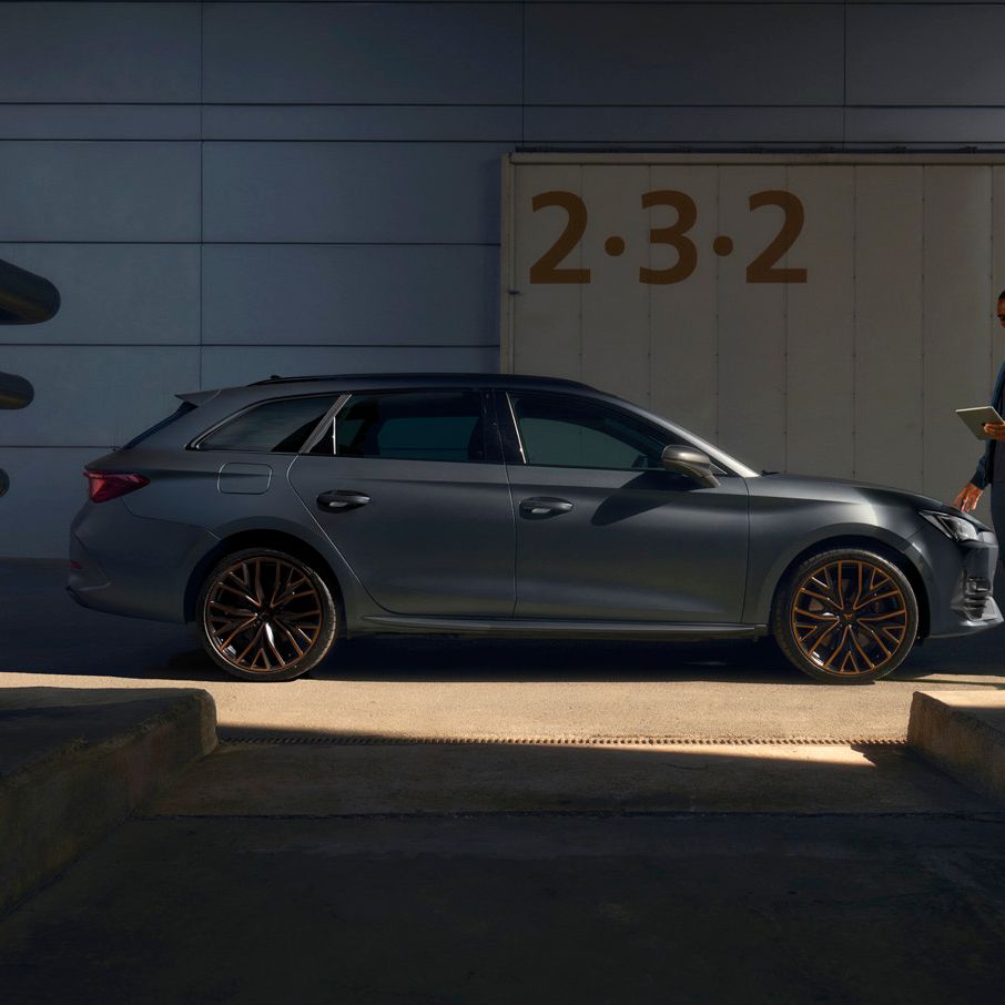 Ein Cupra Techniker mit Tablet neben einem CUPRA Leon SP Kombi.