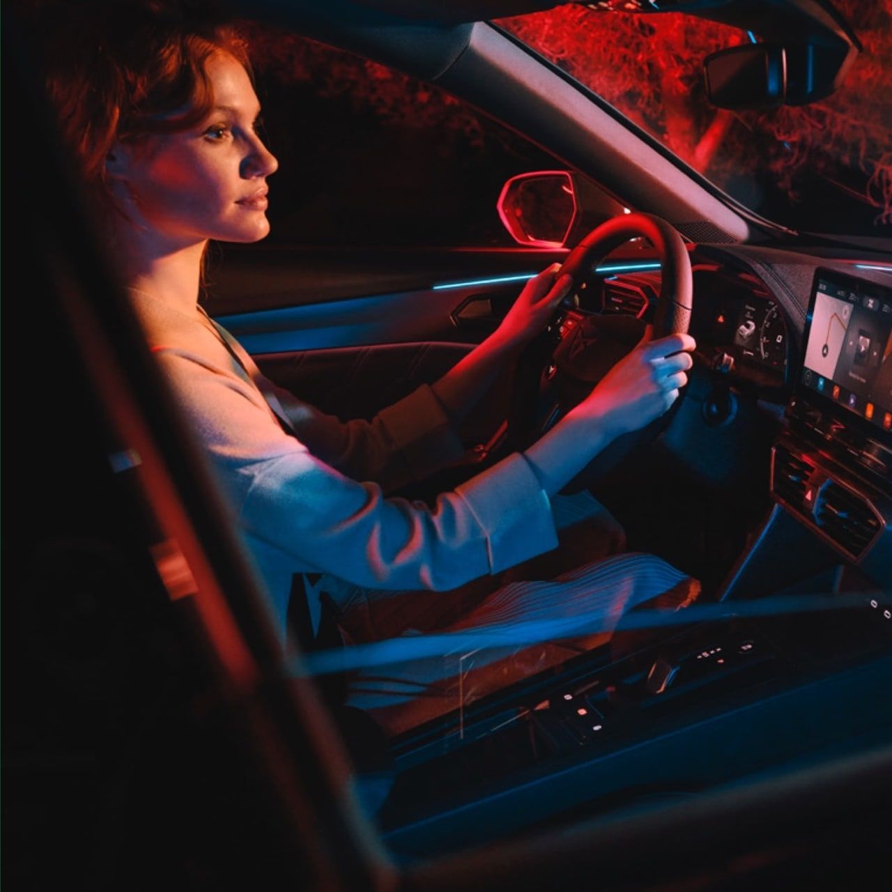 Eine Frau bei Nacht im Cockpit eines CUPRA Formentor.