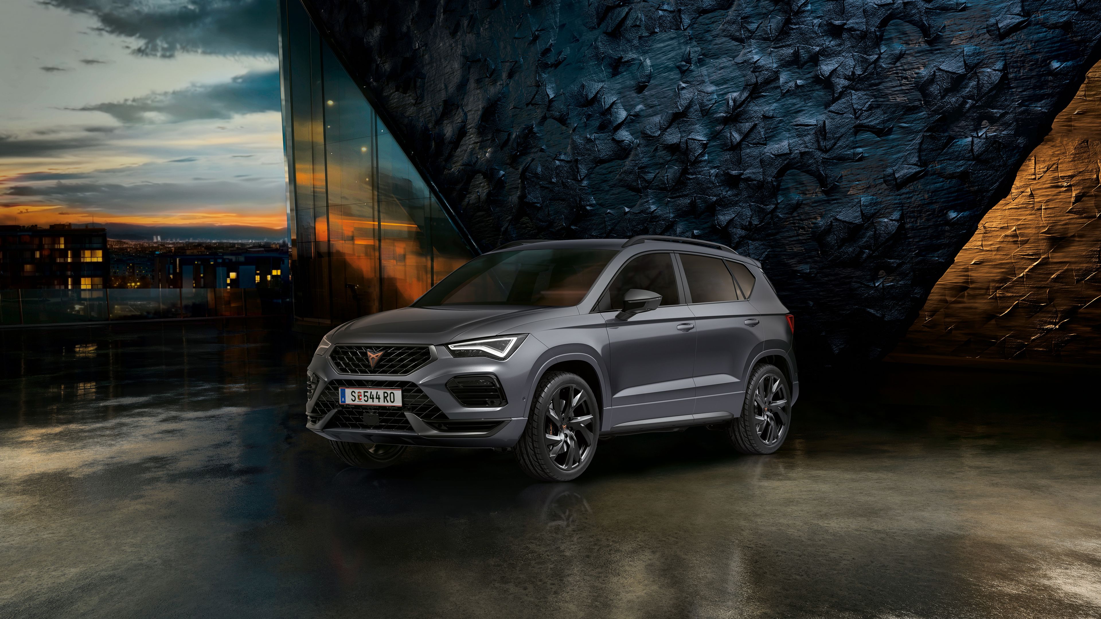 CUPRA Ateca vor einer Steinwand bei Sonnenuntergang