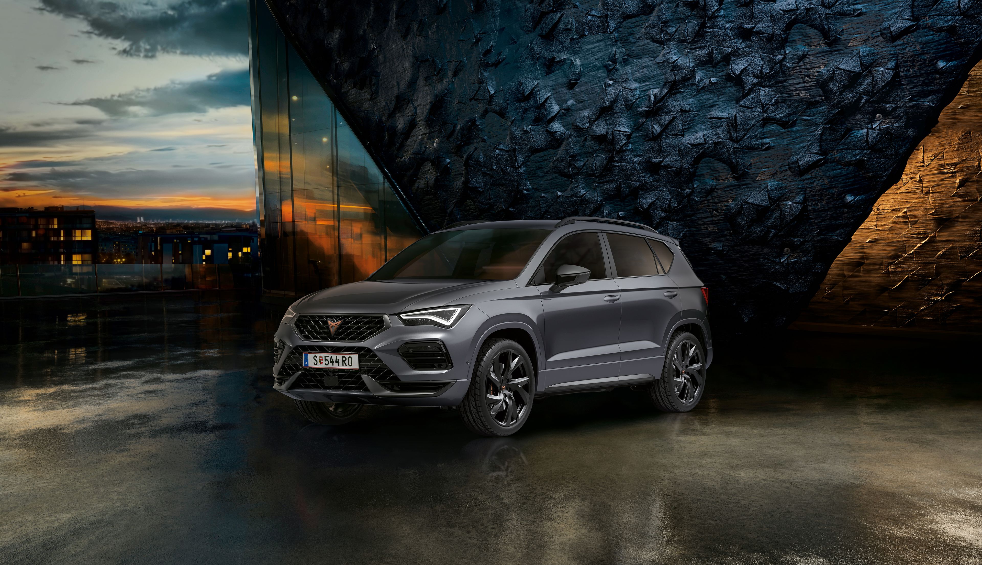 CUPRA Ateca vor einer Steinwand bei Sonnenuntergang