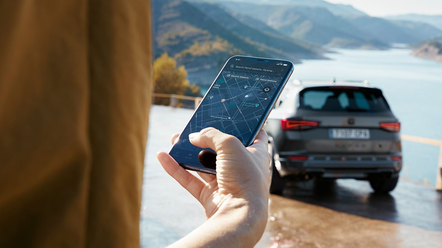 Ein CUPRA Ateca parkt mit Blick auf das Meer und wird über CUPRA Connect mit dem Smartphone verbunden.