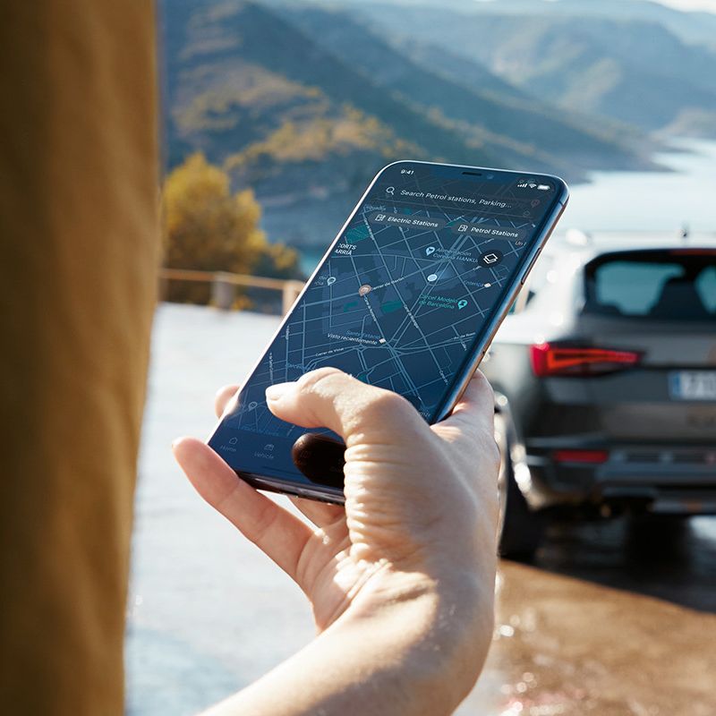 Ein CUPRA Ateca parkt mit Blick auf das Meer und wird über CUPRA Connect mit dem Smartphone verbunden.
