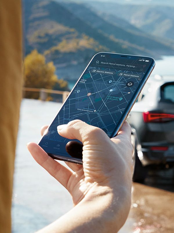 Ein CUPRA Ateca parkt mit Blick auf das Meer und wird über CUPRA Connect mit dem Smartphone verbunden.