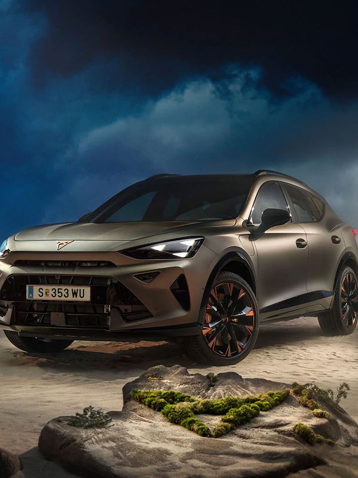 Ein CUPRA Formentor VZ in Bronze steht dramatisch beleuchtet in einer felsigen, nebeligen Landschaft. Eine Lichtstrahl beleuchtet das Fahrzeug und betont seine Konturen. Im Hintergrund sind Felsen und Pflanzen zu sehen.