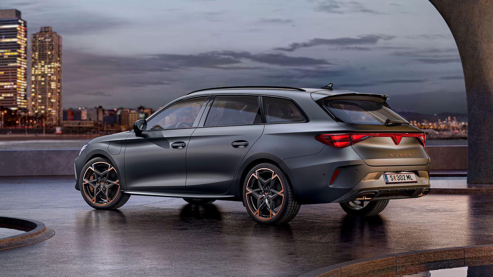 Seitliche Heckansicht eines grauen CUPRA Leon SP Kombi vor der Skyline einer Stadt.