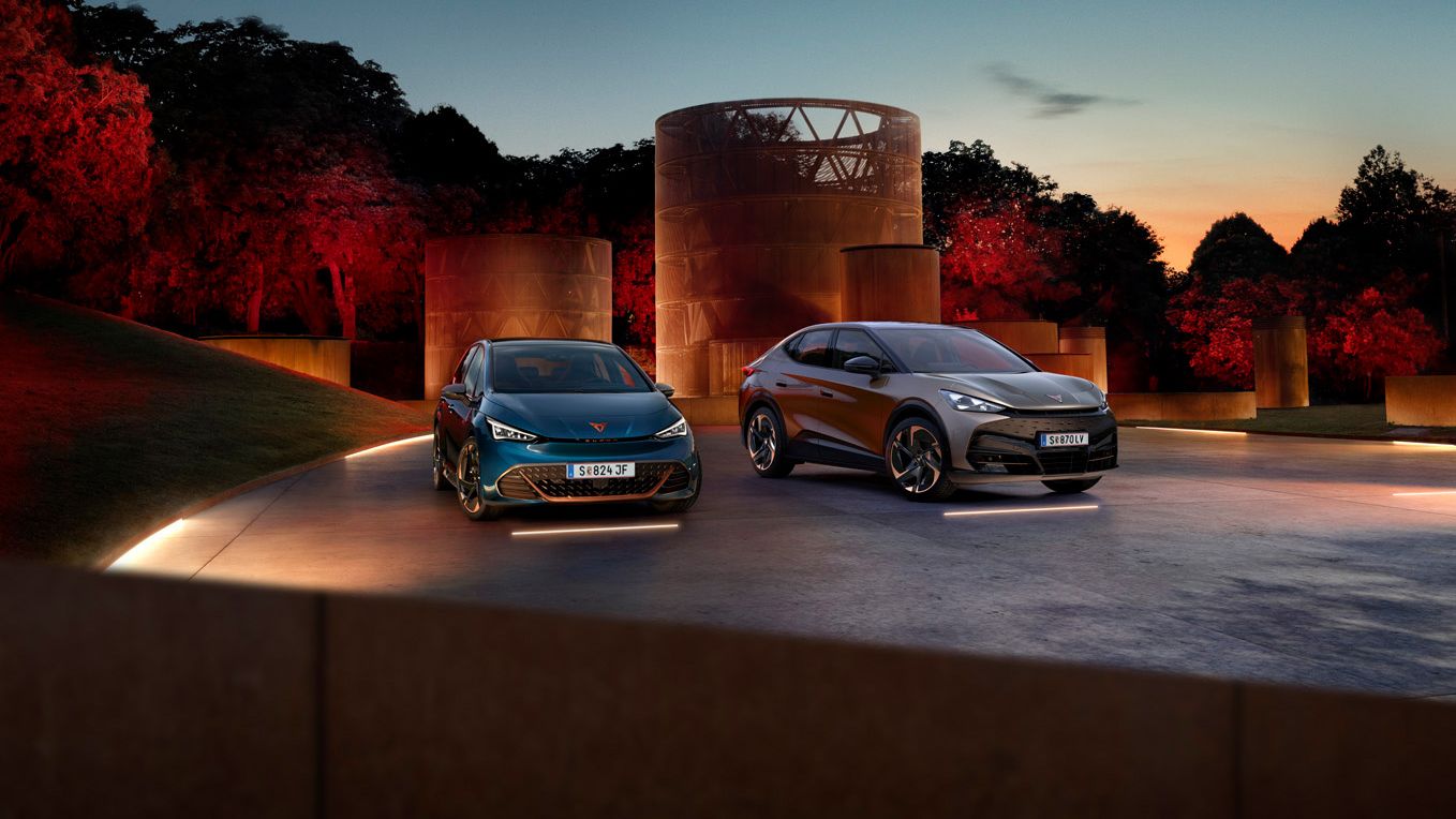 CUPRA Born und Tavascan stehen nebeneinander auf beleuchtetem hintergrund