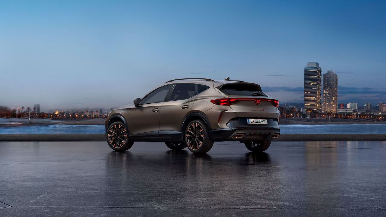 Ein CUPRA Formentor steht auf einer glatten Oberfläche vor einer Stadtlandschaft bei Sonnenaufgang. Im Hintergrund ist das Meer und hohe Gebäude zu sehen.