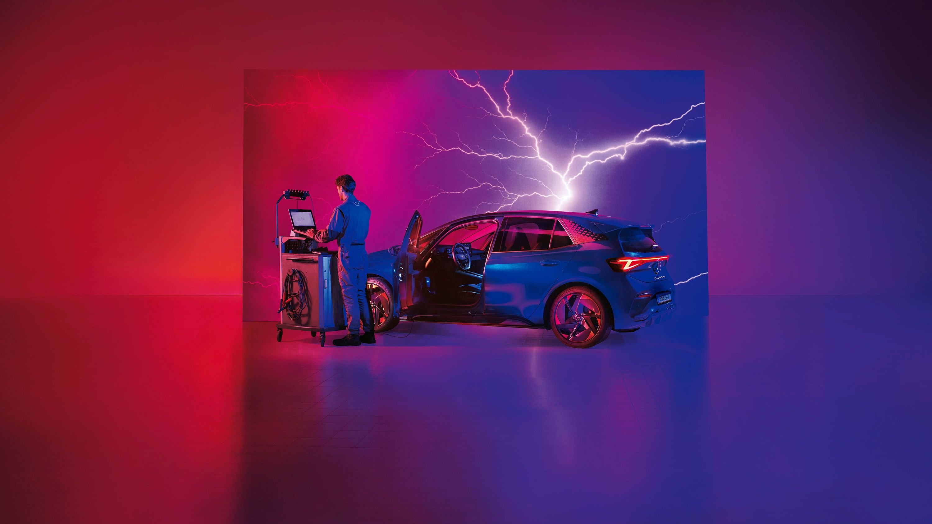 Ein CUPRA Techniker mit Diagnosegräten neben einem CUPRA Born.