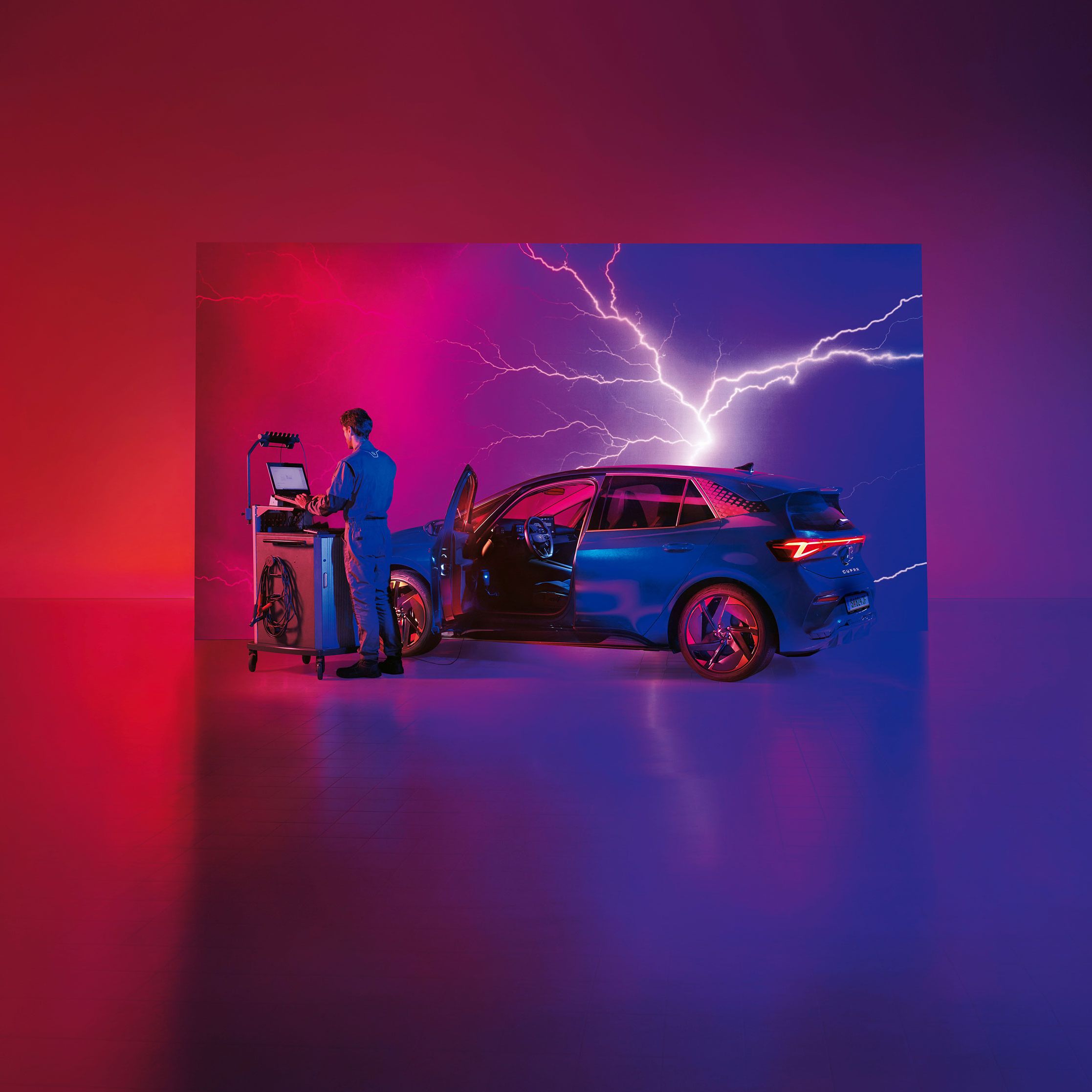 Ein CUPRA Techniker mit Diagnosegräten neben einem CUPRA Born.