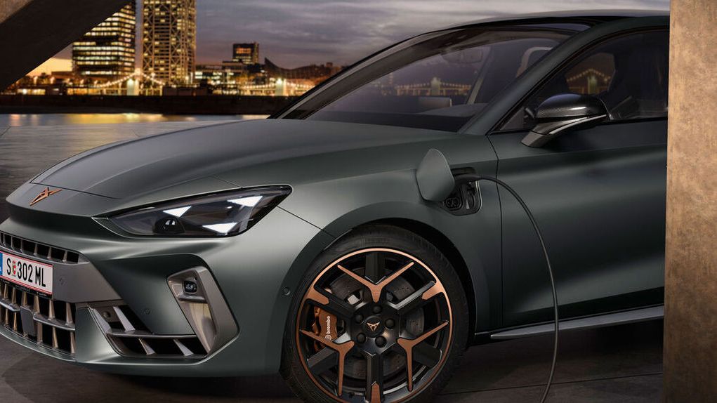 Blick auf die Ladeöffnung eines grauen CUPRA Leon. Das Ladekabel ist angesteckt. 