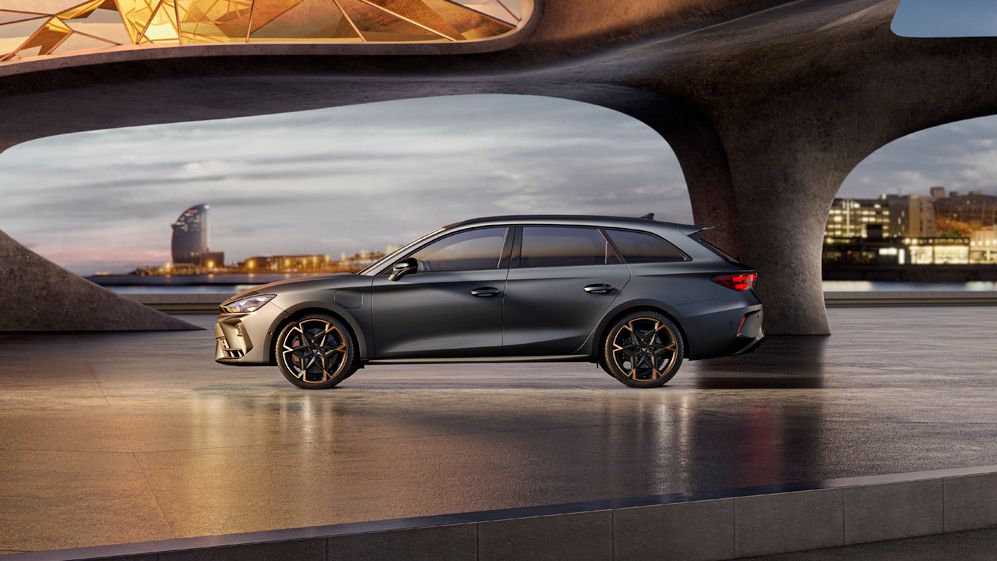 Seitenansicht eines grauen CUPRA Leon SP Kombi, der in einem modernen Parkhaus parkt.