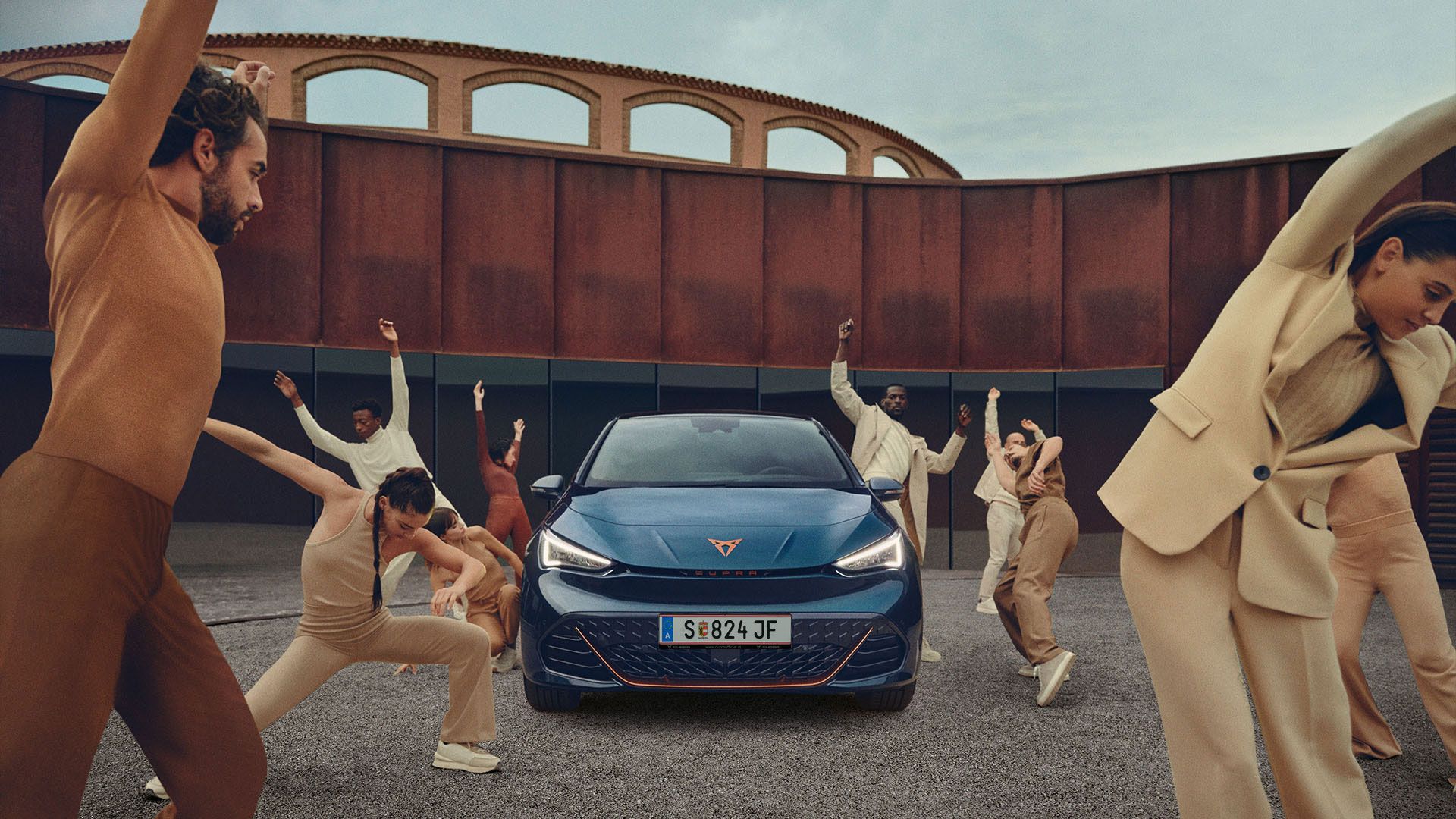 Tänzer posieren um einen blauen CUPRA Born.