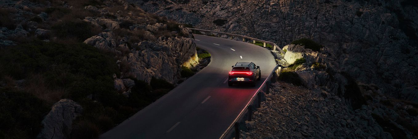 Ein CUPRA Formentor bei Nacht auf einer gebirgigen Küstenstraße