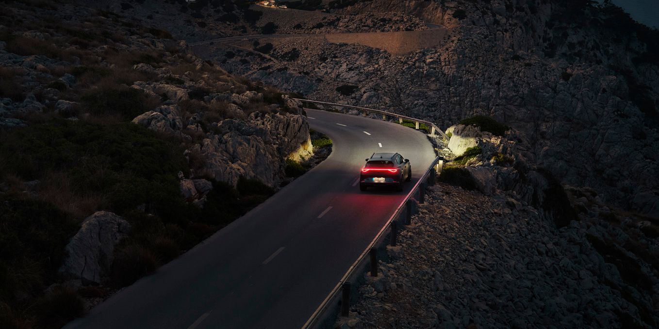 Ein CUPRA Formentor bei Nacht auf einer gebirgigen Küstenstraße