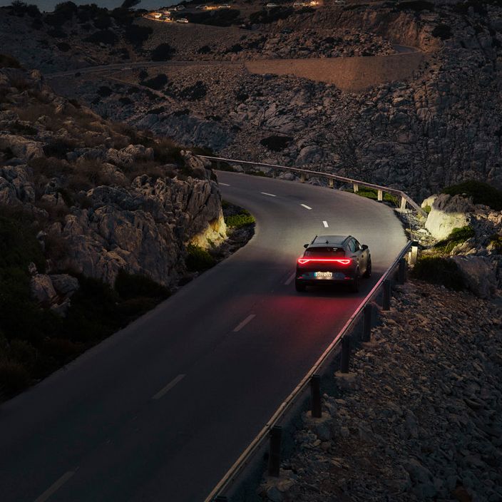 Ein CUPRA Formentor bei Nacht auf einer gebirgigen Küstenstraße