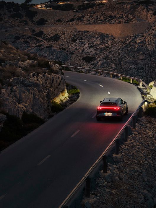 Ein CUPRA Formentor bei Nacht auf einer gebirgigen Küstenstraße