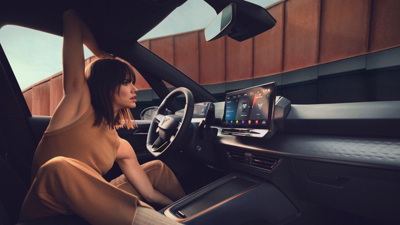 Eine Frau posiert im Cockpit eines CUPRA Born.