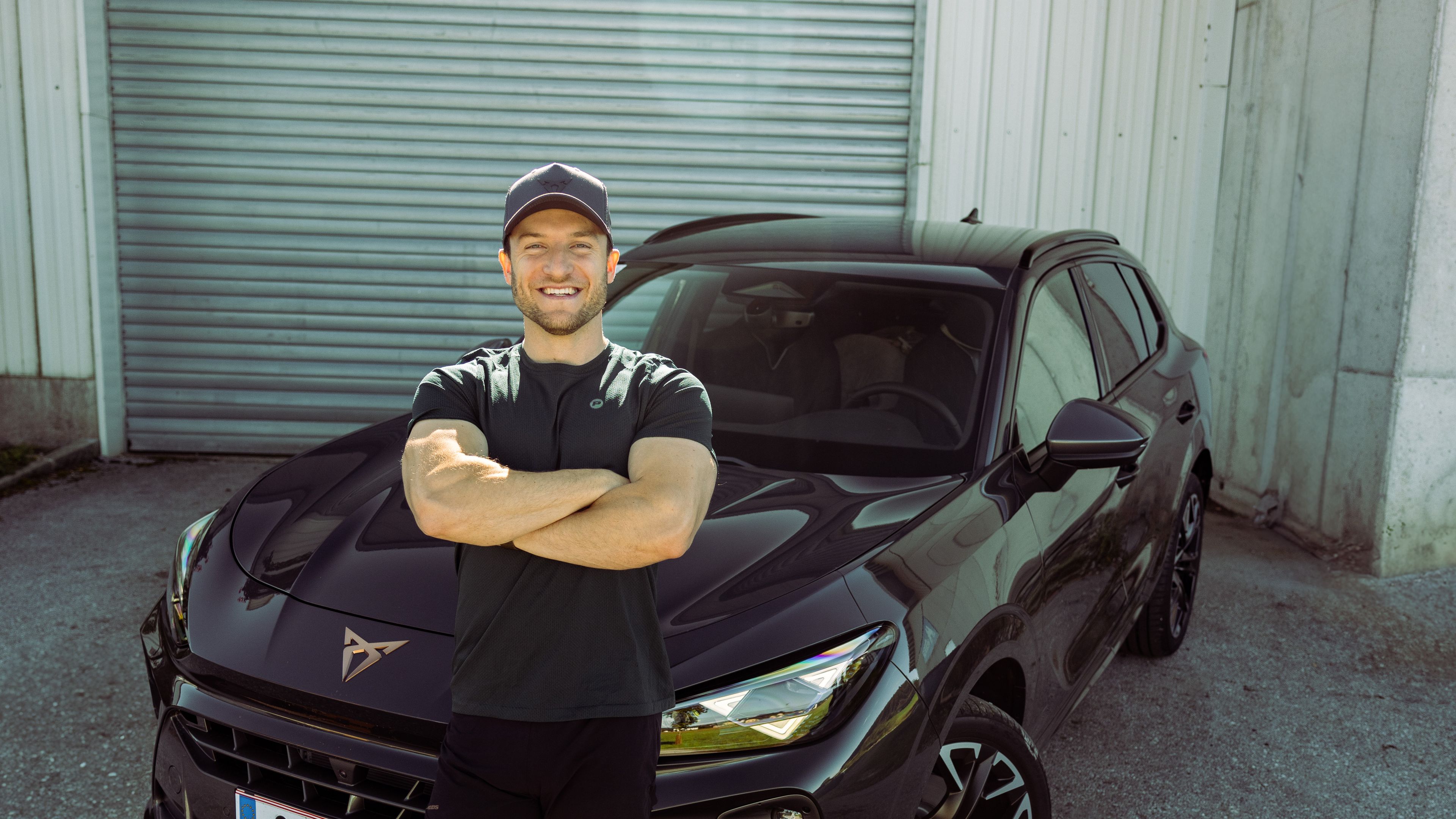 Sascha Huber vor dem CUPRA Terramar vor einem Garagentor