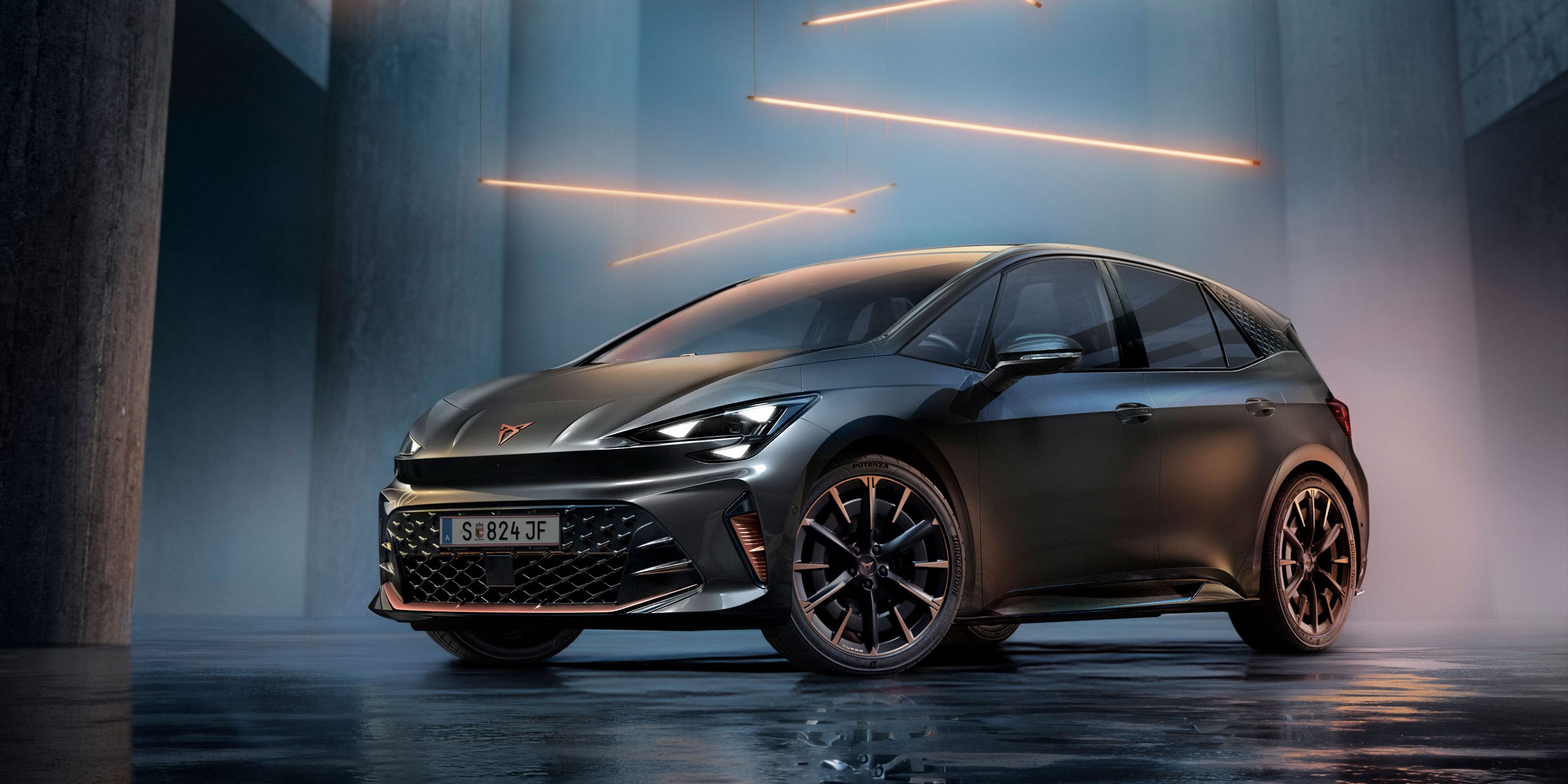 Ein grauer CUPRA Born steht in einer modernen, dunklen Umgebung mit vertikalen Säulen und leuchtenden LED-Streifen. Der Boden ist glänzend und reflektiert das Fahrzeug sowie die Beleuchtung. Das Auto wirkt kraftvoll und elegant.