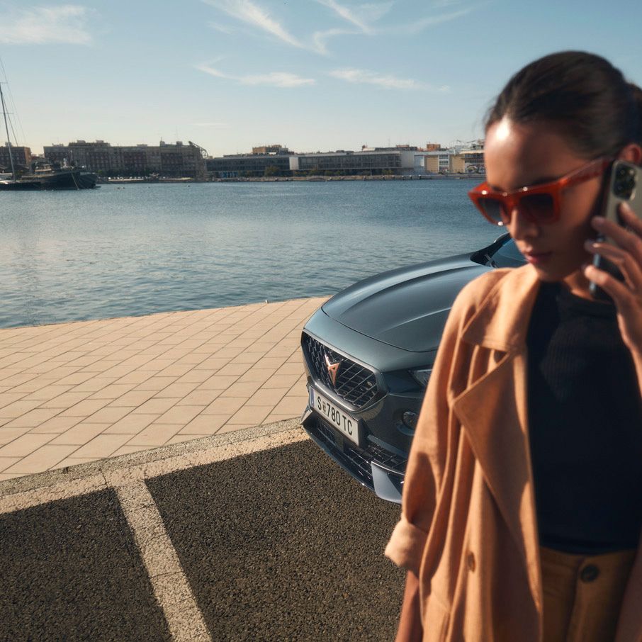 Eine Frau telefoniert vor einem CUPRA Formentor