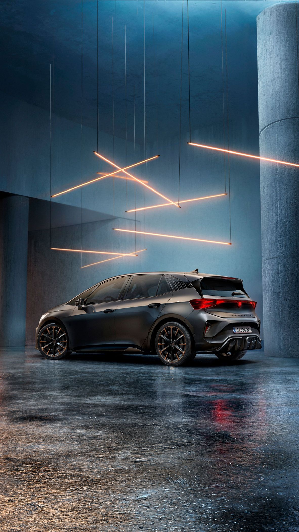 Ein CUPRA Born steht in einem stilvoll beleuchteten, industriellen Raum mit Betonwänden und -säulen. Von der Decke hängen mehrere lineare Lichtquellen, die ein elegantes Ambiente schaffen. Das Fahrzeug ist rückseitig zu sehen und reflektiert das Licht auf dem glänzenden Boden.