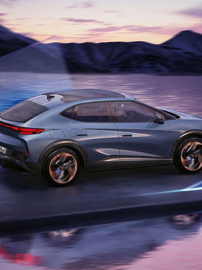 CUPRA Tavascan Seitenansicht vor See mit Bergen im Hintergrund