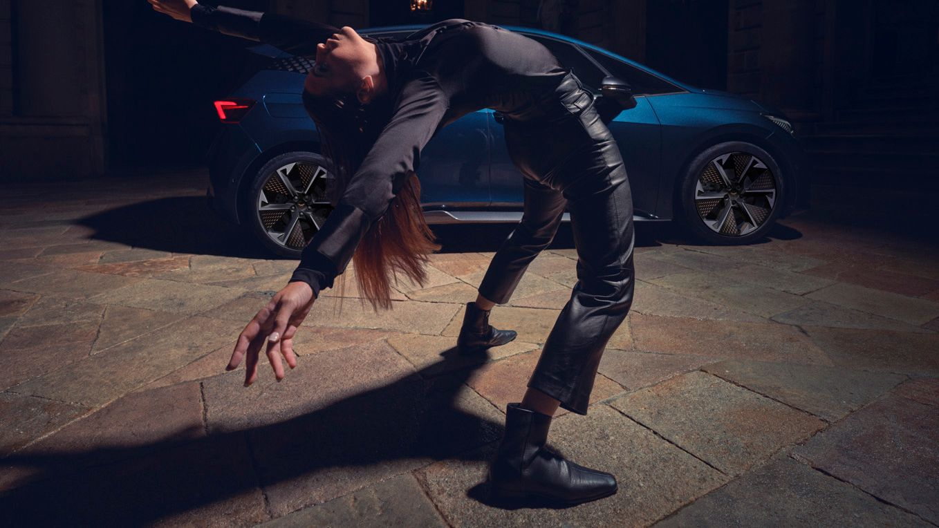 Eine Tänzerin vor einem blauen CUPRA Born.