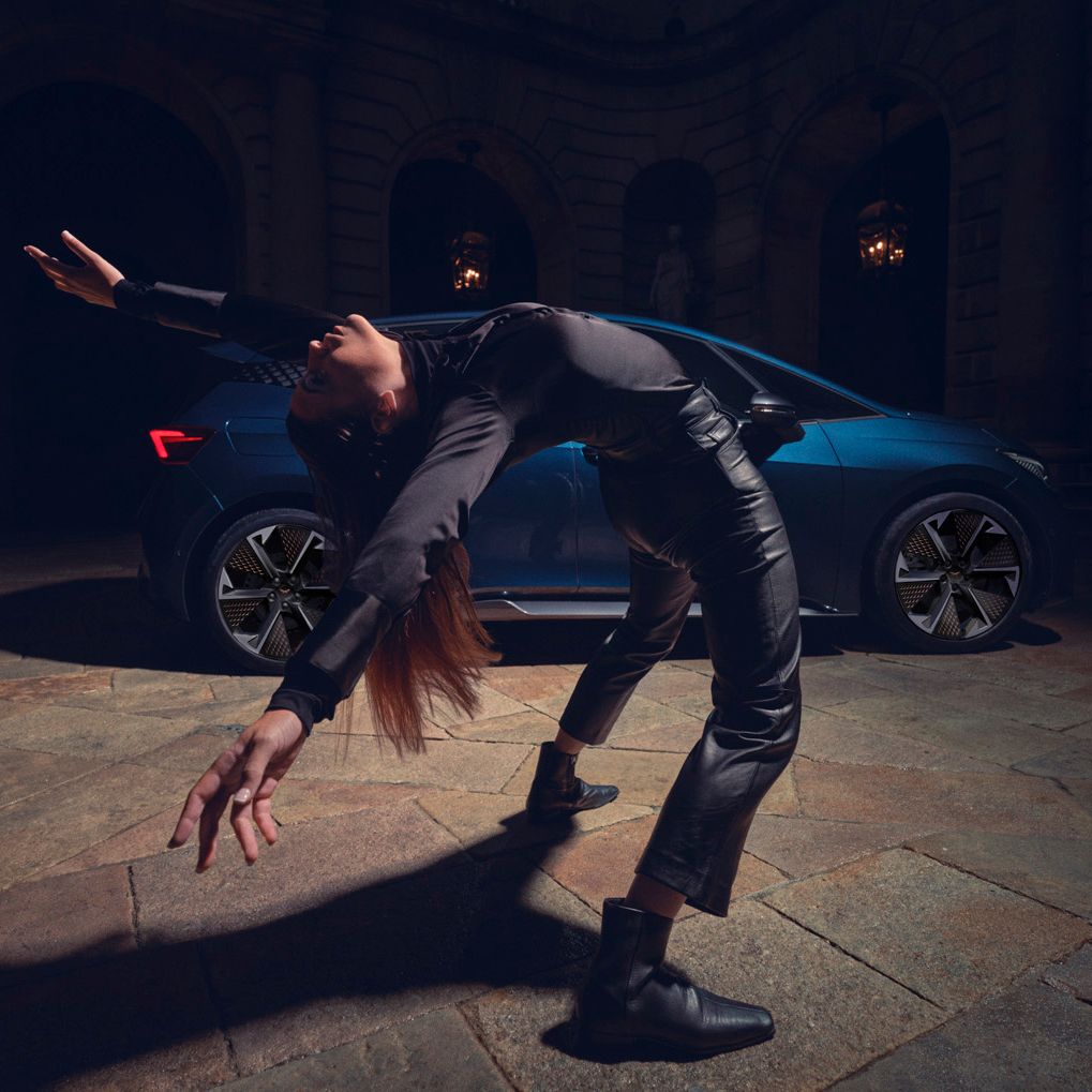 Eine Tänzerin vor einem blauen CUPRA Born.