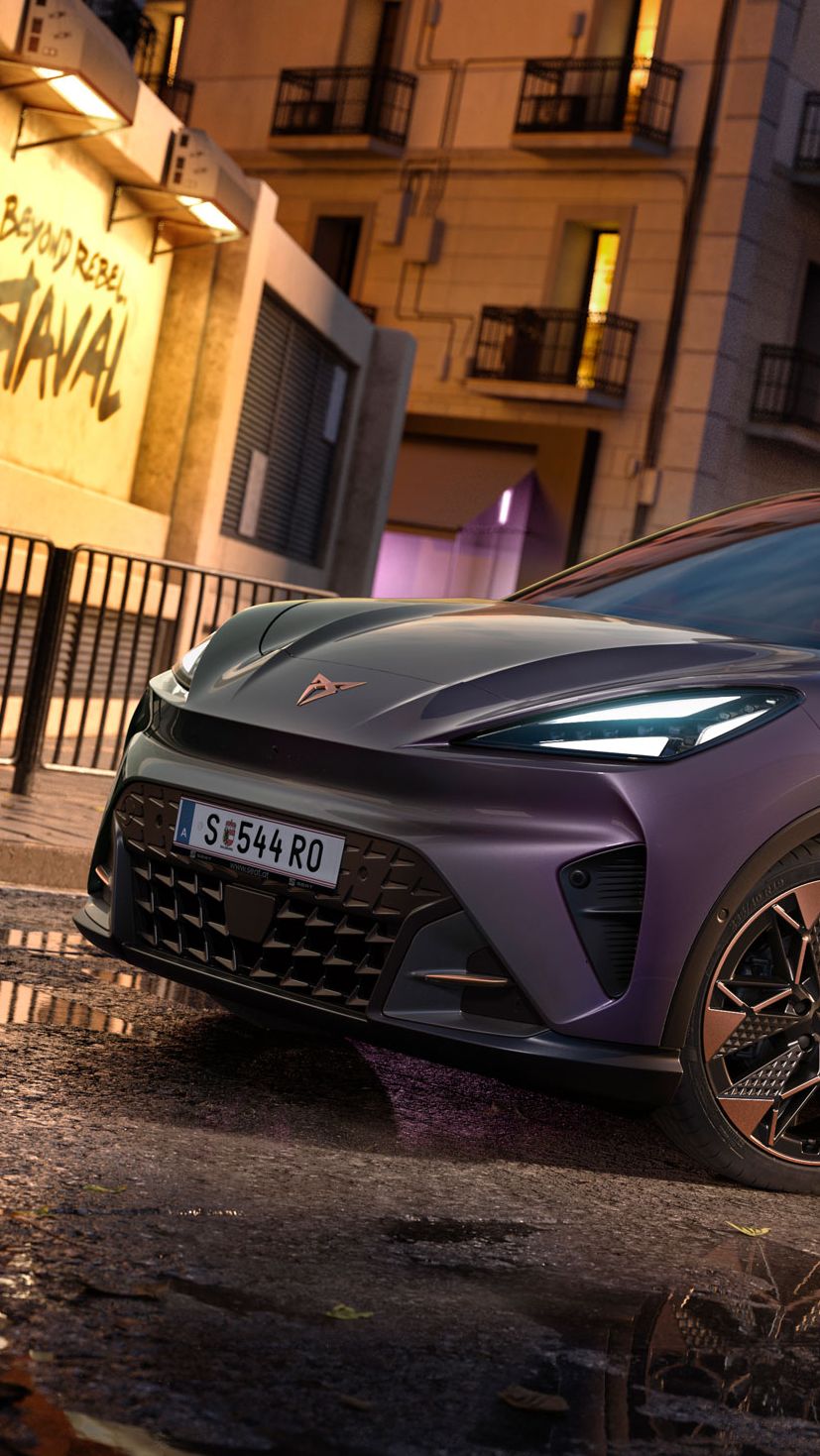 CUPRA Raval VZ in Plasma steht auf einer Straße in urbaner Umgebung